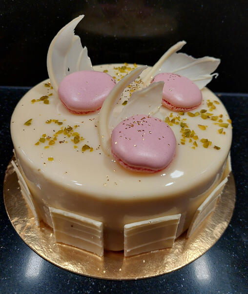 Afbeelding van een witte prinsessen cake gedecoreerd met witte chocolade en macarons